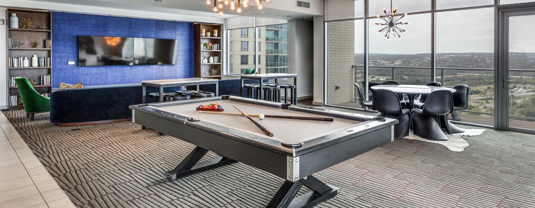 a room with a pool table and chairs